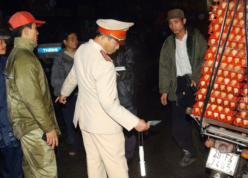 Xảnh sát giao thông kiểm tra một xe gắn máy chở trứng gà.