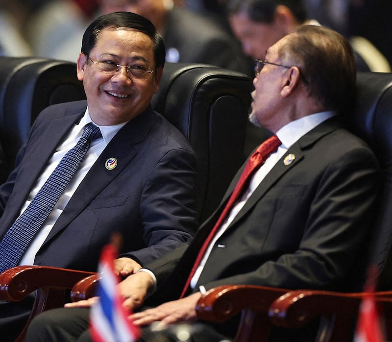 Laos' Prime Minister Sonexay Siphandone, left, chats with Malaysia's Prime Minister Anwar Ibrahim at the closing ceremony of the ASEAN meeting in Vientiane, Oct. 11, 2024. (Athit Perawongmetha/Reuters)