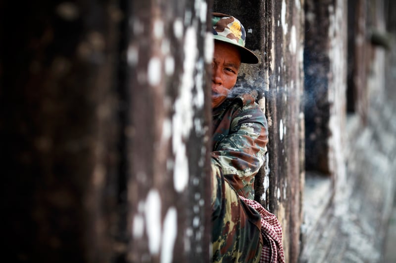 In this Feb. 9, 2011, photo, a Cambodian soldier smokes a cigarette at the 11th-century Preah Vihear temple on the border between Thailand and Cambodia.