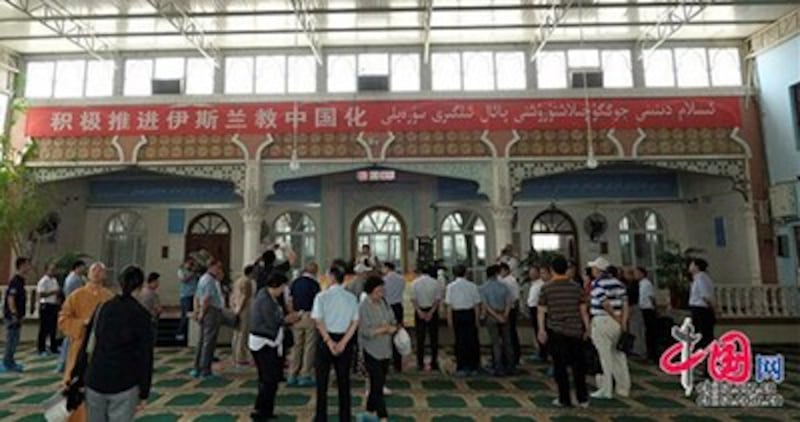 An undated photo from the official China.org.cn website shows a banner inside a mosque in Xinjiang which reads 'Actively Promote Chinese-Style Islam.'