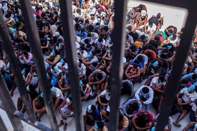 Alleged scam center workers and victims sit on the ground during a crackdown operation by the Karen Border Guard Force (BGF) on illicit activity at the KK Park complex in Myanmar's eastern Myawaddy township on Feb. 26, 2025.