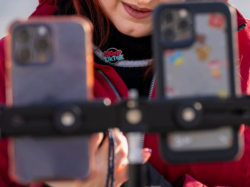 Wearing a button in support of TikTok, Tiffany Cianci, who says she is a "long-form educational content creator," livestreams to TikTok outside the Supreme Court, Jan. 10, 2025, in Washington.