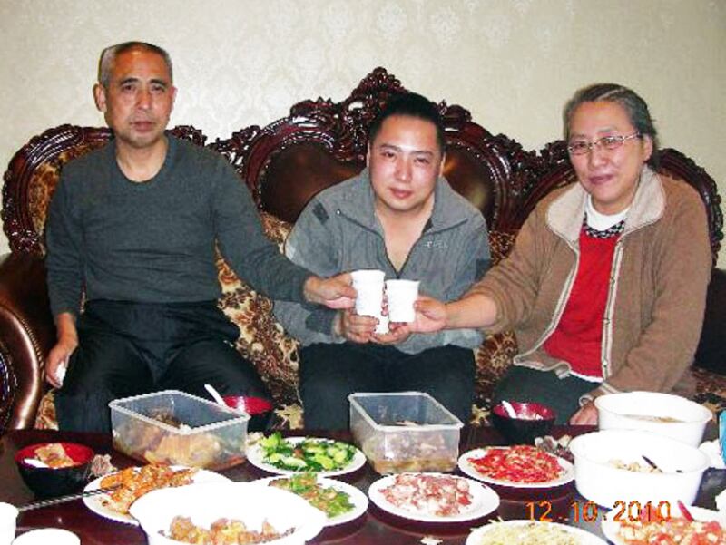 Mongolian dissident Hada, left, shares a meal with son Uiles, center, and wife Xinna in undated photo.
