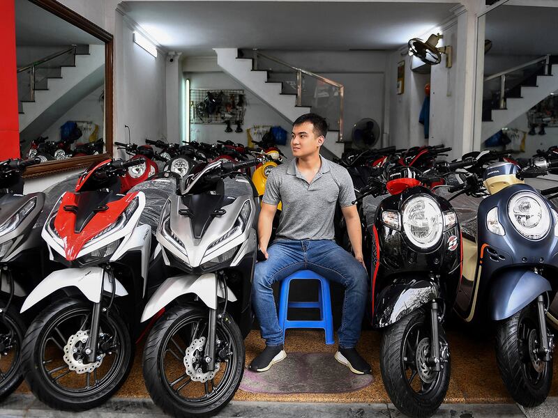 A salesman waits for customers at a motorcycle and scooter showroom in Hanoi, VIetnam,  March 29, 2021.