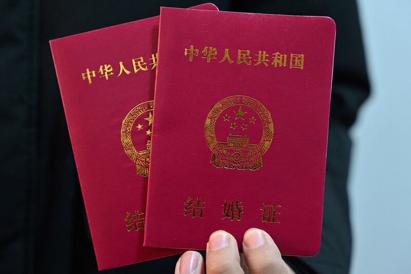 A newlywed man shows marriage books for him and his wife in Luliang, northern China's Shanxi province on Feb.11, 2025.